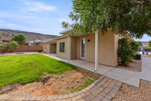 Rear view of house featuring stucco siding, a mountain view, and a patio