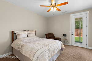 Bedroom with light colored carpet, access to outside, and a ceiling fan