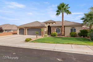 Mediterranean / spanish home featuring stone siding, stucco siding, concrete driveway, a front yard, and a garage