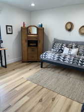 Living room with light wood-style flooring and recessed lighting
