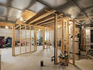 Below grade area featuring heating unit and secured water heater