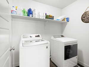 Laundry area featuring washing machine and dryer and dark wood-style floors