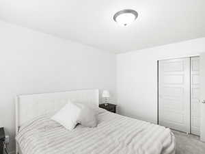 Carpeted bedroom with a closet