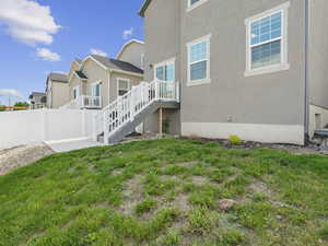 Rear view of house with a patio, stairs, stucco siding, and a residential view