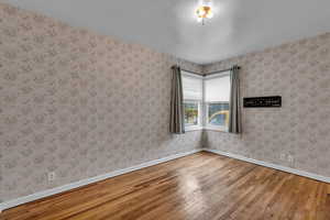 Empty room with hardwood / wood-style flooring and baseboards