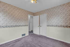 Unfurnished bedroom with carpet flooring and baseboards