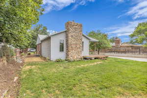 View of property exterior featuring a wooden deck and a chimney