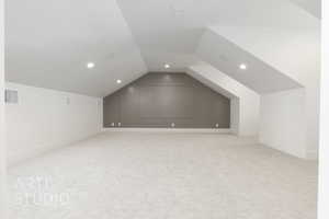 Bonus room with lofted ceiling, light carpet, and recessed lighting