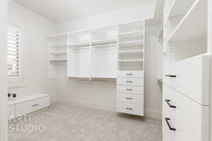 Walk in closet featuring light carpet