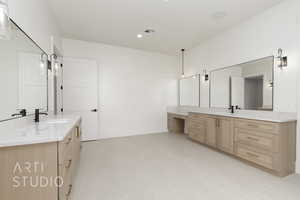 Bathroom featuring two vanities, recessed lighting, and light tile patterned flooring