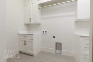 Laundry area featuring hookup for a washing machine, hookup for an electric dryer, light tile patterned floors, and gas dryer hookup