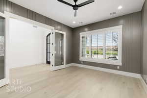 Unfurnished room featuring light wood-style flooring, ceiling fan, recessed lighting, and french doors