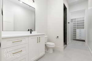 Full bath with vanity, light tile patterned flooring, and a spacious closet