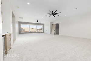 Unfurnished living room featuring a barn door, light carpet, recessed lighting, and a ceiling fan