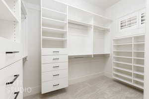 Walk in closet featuring light carpet