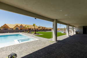 View of swimming pool featuring a patio, a fenced backyard, a pool with connected hot tub, and a residential view