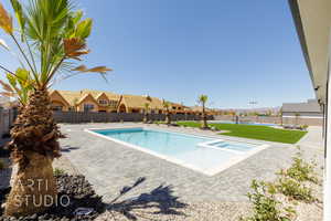 View of swimming pool featuring a patio area, a residential view, a fenced backyard, and a pool with connected hot tub