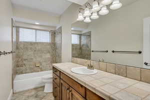 Full bath featuring vanity, shower / bathtub combination, and light tile patterned flooring