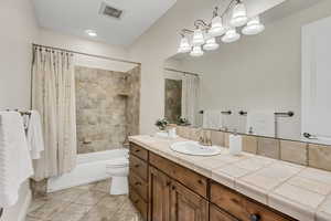 Full bath featuring shower / bath combo, light tile patterned floors, and vanity