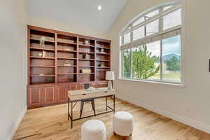 Office with light wood-style flooring, lofted ceiling, and recessed lighting