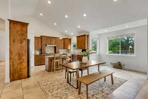 Dining area with recessed lighting, light tile patterned floors, and high vaulted ceiling