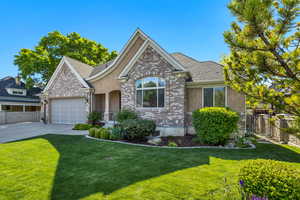 View of front of house with brick siding, driveway, an attached garage, and stucco siding