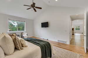 Bedroom with light wood-style flooring, high vaulted ceiling, and ceiling fan