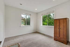 Unfurnished bedroom with light carpet and recessed lighting