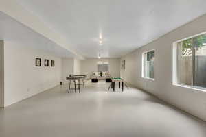 Recreation room featuring concrete flooring