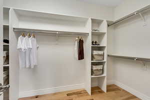 Walk in closet with light wood-style floors