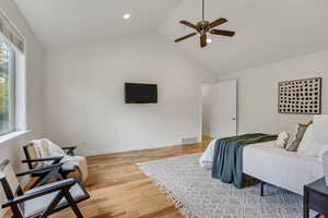 Bedroom with light wood-type flooring, ceiling fan, high vaulted ceiling, and recessed lighting