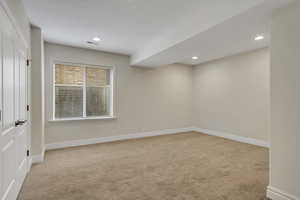 Spare room with light carpet and recessed lighting