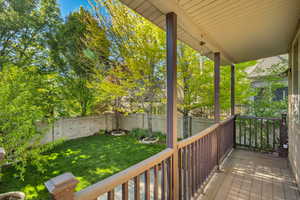 Wooden porch with a fenced backyard