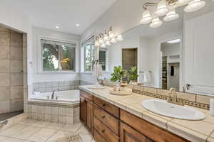 Full bath with a bath, double vanity, light tile patterned floors, and recessed lighting
