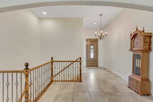 Tiled entrance foyer featuring a chandelier and recessed lighting