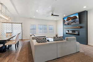 Living area featuring a textured ceiling, a large fireplace, recessed lighting, and a ceiling fan
