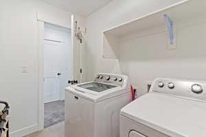 Washroom featuring light tile patterned floors and washing machine and dryer
