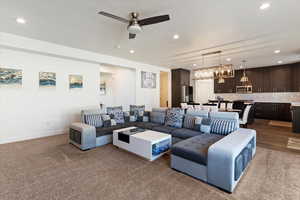 Living area featuring recessed lighting, dark colored carpet, and ceiling fan