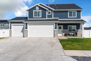 Craftsman house with board and batten siding, a gate, driveway, and covered porch
