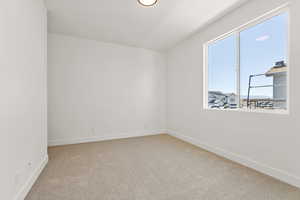 Spare room featuring light colored carpet and baseboards
