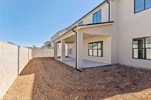Back of house featuring stucco siding, a patio, and a fenced backyard
