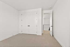 Unfurnished bedroom with carpet flooring and a closet