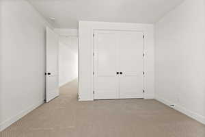 Unfurnished bedroom with carpet and a closet
