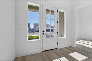 Doorway featuring baseboards and wood finished floors