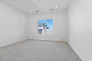 Unfurnished room with light colored carpet and recessed lighting