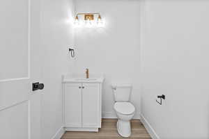 Half bathroom with vanity and light wood-type flooring