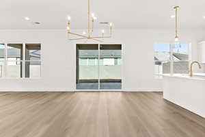 Unfurnished dining area featuring light wood-style floors, a chandelier, and recessed lighting