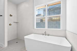 Full bathroom featuring a soaking tub, tile walls, a walk in shower, and tile patterned floors