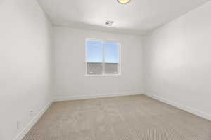 Empty room featuring carpet flooring and baseboards