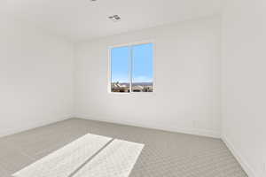 Spare room with light carpet and baseboards